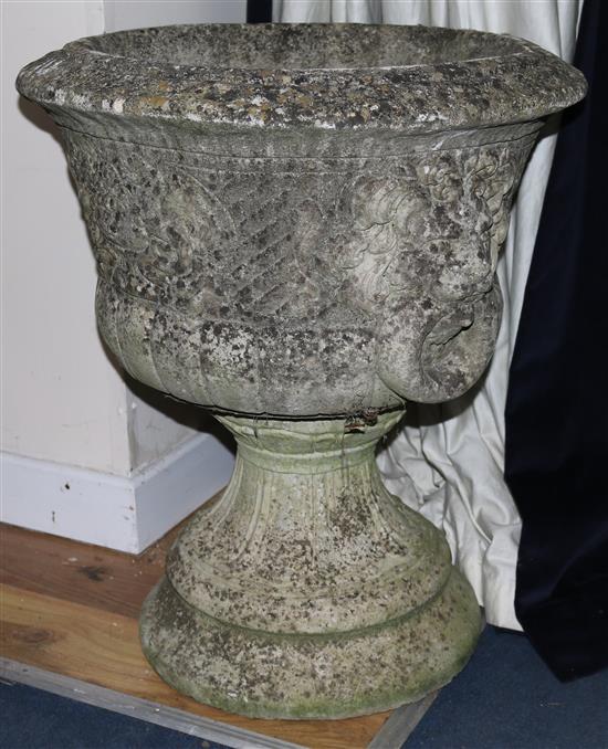 An embossed stone urn, with lion ring decoration on acanthus leaf base, H.65cm
